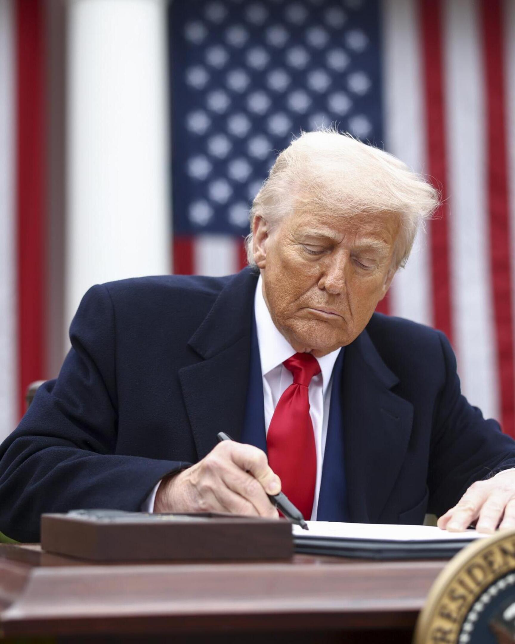 Donald Trump ondertekent het decreet met de nieuwe importtarieven.
